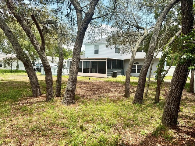 3181 Deltona Blvd, Spring Hill, FL 34606 - back of property with a sunroom and a lawn