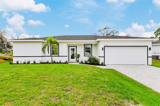 12167 Florence Ave, Port Charlotte, FL 33981 - ranch-style home with central AC unit, a garage, decorative driveway, and a front yard