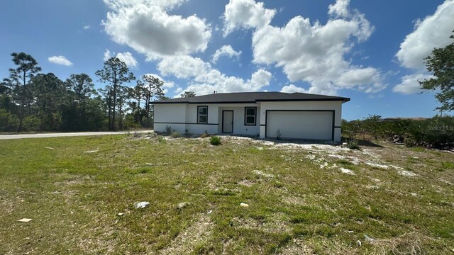 12167 Florence Ave, Port Charlotte, FL 33981 - view of front of house featuring an attached garage, stucco siding, and a front lawn