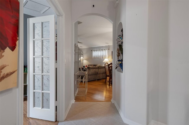 6303 Gentle Ben Cir, Wesley Chapel, FL 33544 - hallway with arched walkways, light tile patterned floors, and baseboards