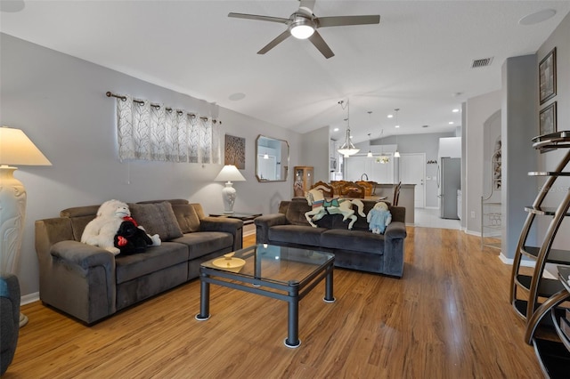 6303 Gentle Ben Cir, Wesley Chapel, FL 33544 - living area with ceiling fan, vaulted ceiling, light wood-style floors, and baseboards