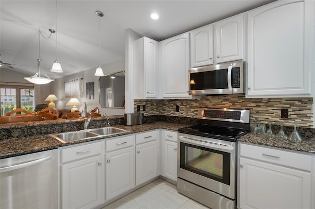6303 Gentle Ben Cir, Wesley Chapel, FL 33544 - kitchen featuring stainless steel appliances, a sink, tasteful backsplash, dark stone countertops, and white cabinetry