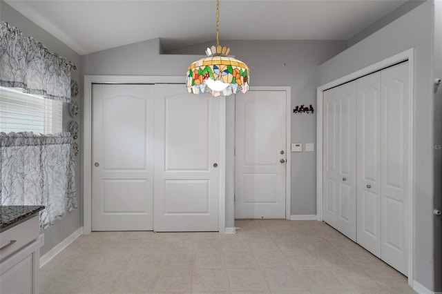 6303 Gentle Ben Cir, Wesley Chapel, FL 33544 - unfurnished dining area with lofted ceiling, light tile patterned floors, and baseboards
