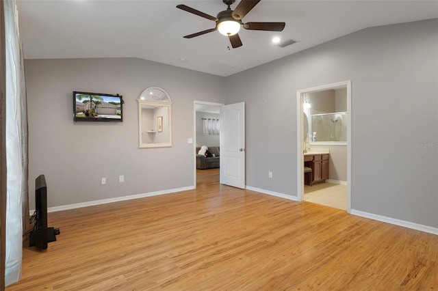 6303 Gentle Ben Cir, Wesley Chapel, FL 33544 - unfurnished bedroom with lofted ceiling, light wood-style floors, baseboards, and ensuite bathroom