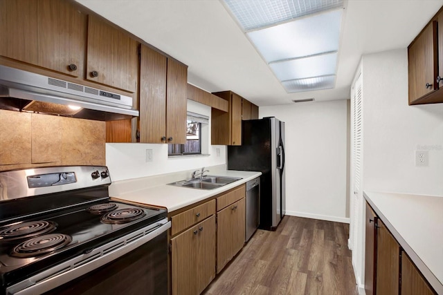 8630 Cattail Dr Unit 8630, Temple Terrace, FL 33637 - kitchen featuring stainless steel appliances, under cabinet range hood, a sink, dark wood-type flooring, and light countertops