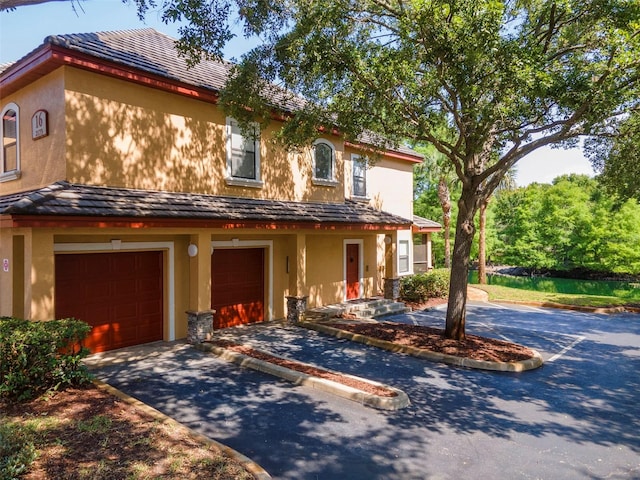 2173 Tuscany Trce Unit 8, Palm Harbor, FL 34683 - view of front of home with a garage, stucco siding, and driveway