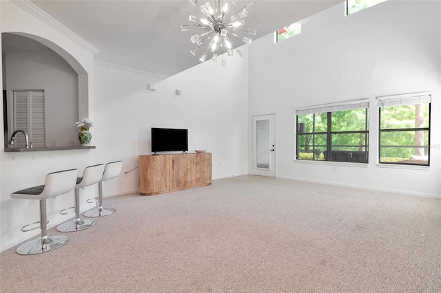2173 Tuscany Trce Unit 8, Palm Harbor, FL 34683 - unfurnished living room with carpet floors, a chandelier, ornamental molding, baseboards, and a sink