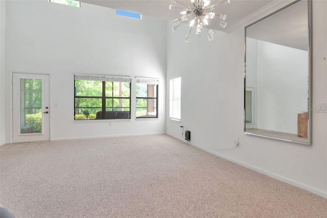 2173 Tuscany Trce Unit 8, Palm Harbor, FL 34683 - spare room featuring a chandelier, carpet floors, baseboards, a high ceiling, and ornamental molding