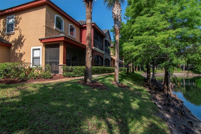 2173 Tuscany Trce Unit 8, Palm Harbor, FL 34683 - back of property with stucco siding, a yard, and a water view