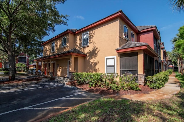 2173 Tuscany Trce Unit 8, Palm Harbor, FL 34683 - view of front of property featuring stucco siding, a tile roof, and a sunroom