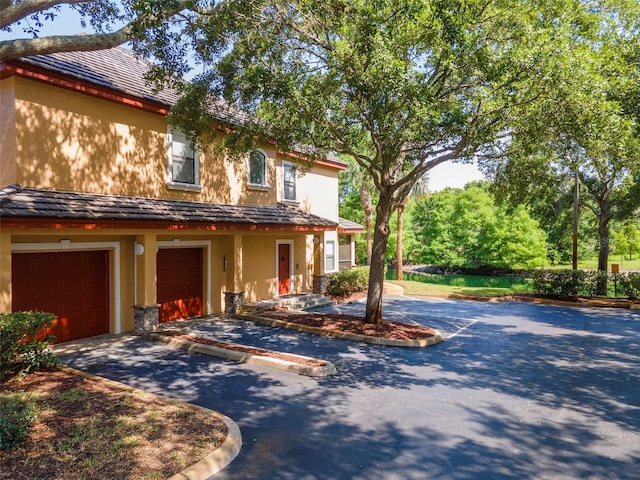 2173 Tuscany Trce Unit 8, Palm Harbor, FL 34683 - view of front of house featuring stucco siding, asphalt driveway, and an attached garage