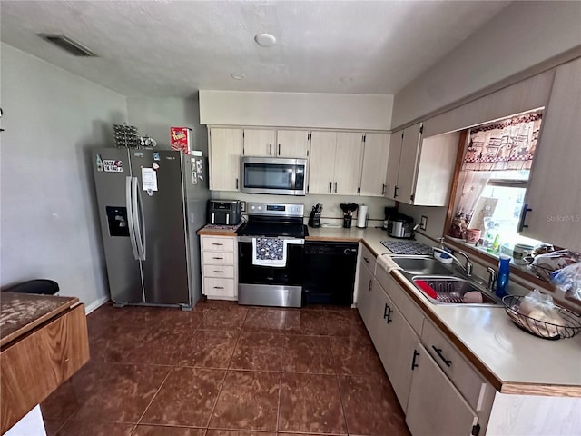 603 Southwood Cv, Brandon, FL 33511 - kitchen featuring stainless steel appliances, dark tile patterned flooring, light countertops, and a sink