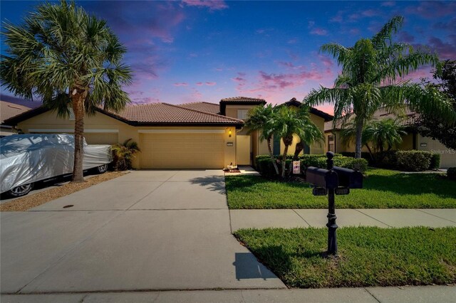 5646 Sunset Falls Dr, Apollo Beach, FL 33572 - mediterranean / spanish-style house featuring a garage, a tile roof, driveway, stucco siding, and a front yard
