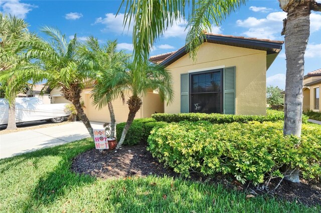 5646 Sunset Falls Dr, Apollo Beach, FL 33572 - view of side of property featuring stucco siding, a garage, and driveway
