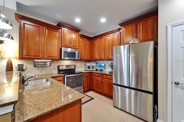 5646 Sunset Falls Dr, Apollo Beach, FL 33572 - kitchen with appliances with stainless steel finishes, a sink, light stone countertops, brown cabinets, and backsplash