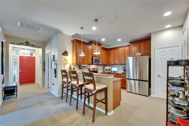 5646 Sunset Falls Dr, Apollo Beach, FL 33572 - kitchen featuring appliances with stainless steel finishes, a peninsula, light colored carpet, brown cabinetry, and recessed lighting