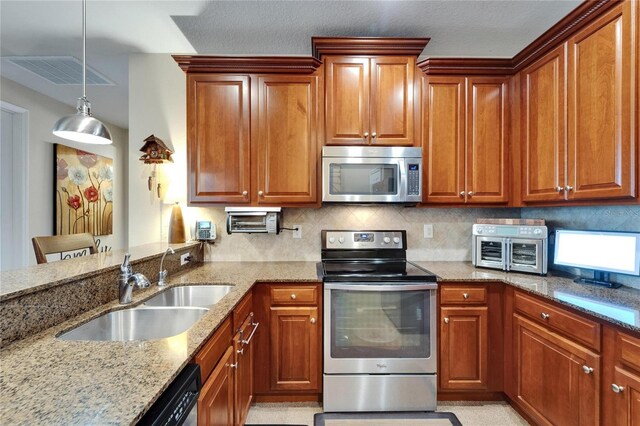 5646 Sunset Falls Dr, Apollo Beach, FL 33572 - kitchen featuring appliances with stainless steel finishes, a sink, light stone counters, and brown cabinetry