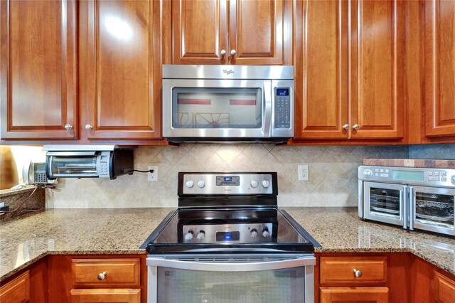 5646 Sunset Falls Dr, Apollo Beach, FL 33572 - kitchen with stainless steel appliances, backsplash, and brown cabinets
