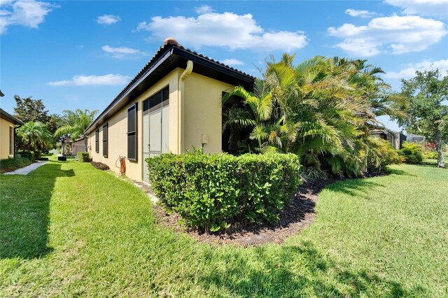 5646 Sunset Falls Dr, Apollo Beach, FL 33572 - view of property exterior featuring stucco siding, a yard, and a tiled roof