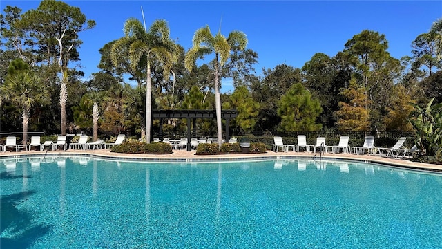 2247 Midnight Pearl Dr, Sarasota, FL 34240 - community pool with view of wooded area, a patio, and a pergola