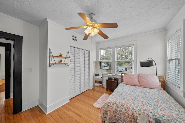 6251 4th Ave S, Saint Petersburg, FL 33707 - bedroom with light wood finished floors, baseboards, a textured ceiling, crown molding, and a ceiling fan