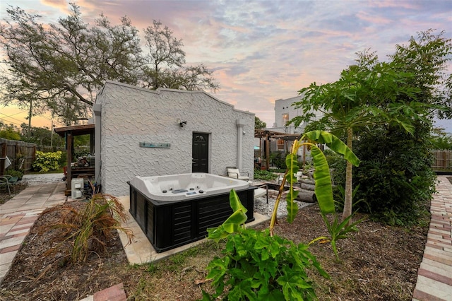 6251 4th Ave S, Saint Petersburg, FL 33707 - back of house with a hot tub and stucco siding