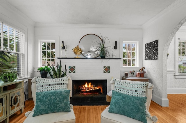 6251 4th Ave S, Saint Petersburg, FL 33707 - living area featuring a fireplace with flush hearth, healthy amount of natural light, wood finished floors, crown molding, and baseboards