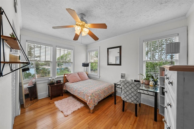 6251 4th Ave S, Saint Petersburg, FL 33707 - bedroom featuring light wood-style floors, crown molding, a textured ceiling, and ceiling fan