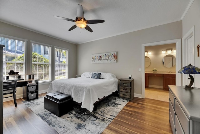 110 Aberdeen Pond Dr, Apollo Beach, FL 33572 - bedroom featuring crown molding, wood finished floors, ensuite bath, baseboards, and a sink