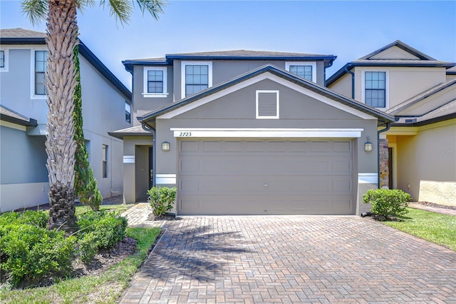 2723 Garden Falls Dr, Brandon, FL 33511 - view of front of property with stucco siding, decorative driveway, and an attached garage
