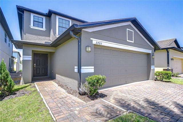 2723 Garden Falls Dr, Brandon, FL 33511 - view of front of property with stucco siding, an attached garage, and decorative driveway