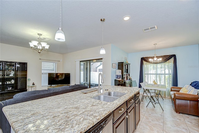 2723 Garden Falls Dr, Brandon, FL 33511 - kitchen with a chandelier, a sink, open floor plan, light stone counters, and a textured ceiling
