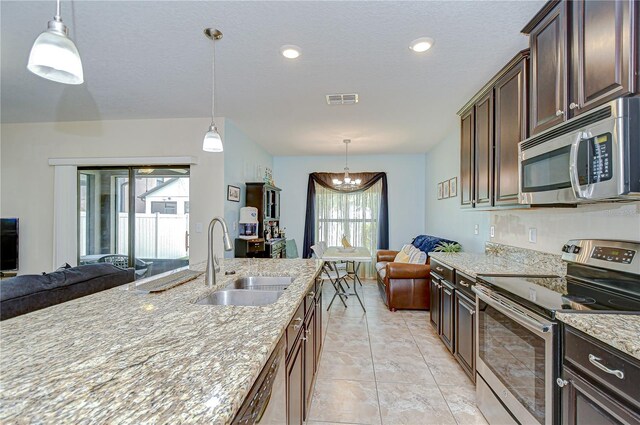 2723 Garden Falls Dr, Brandon, FL 33511 - kitchen with stainless steel appliances, a sink, open floor plan, light stone counters, and recessed lighting