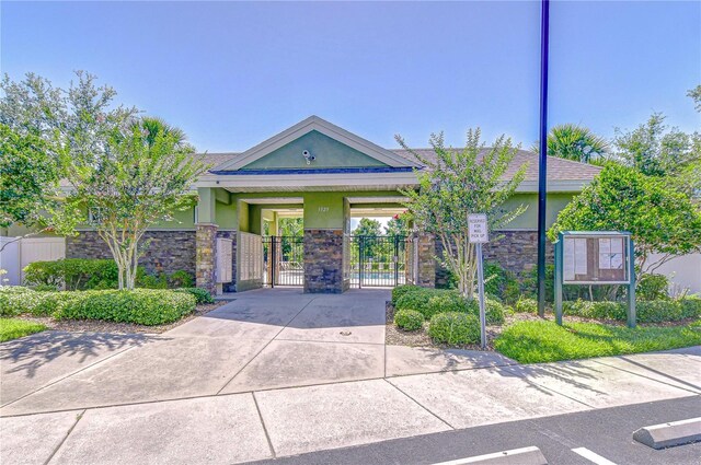 2723 Garden Falls Dr, Brandon, FL 33511 - view of front of home with a gate, stucco siding, and stone siding