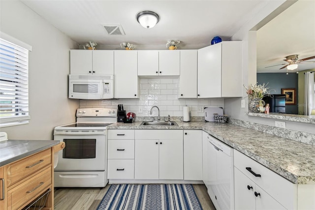 13920 Berkowitz Ave, Hudson, FL 34667 - kitchen featuring white appliances, a sink, light countertops, light wood finished floors, and white cabinets