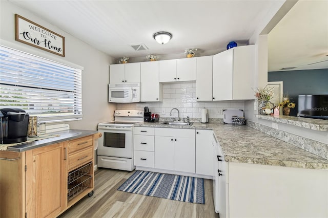 13920 Berkowitz Ave, Hudson, FL 34667 - kitchen featuring white appliances, a sink, light wood-type flooring, light countertops, and white cabinetry