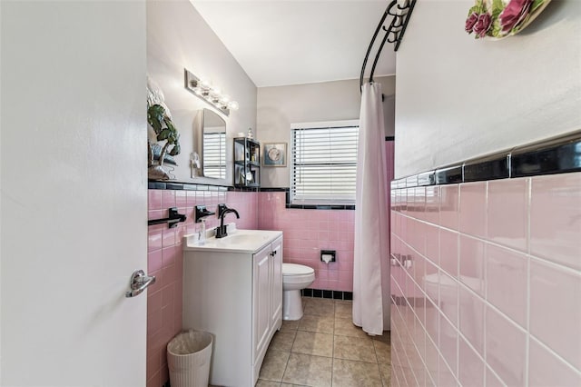 13920 Berkowitz Ave, Hudson, FL 34667 - full bathroom with tile walls, tile patterned floors, toilet, vanity, and a wainscoted wall