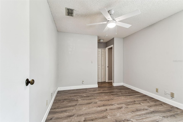 39650 US Highway 19 N Unit 143, Tarpon Springs, FL 34689 - unfurnished bedroom featuring a textured ceiling, wood finished floors, baseboards, and a ceiling fan