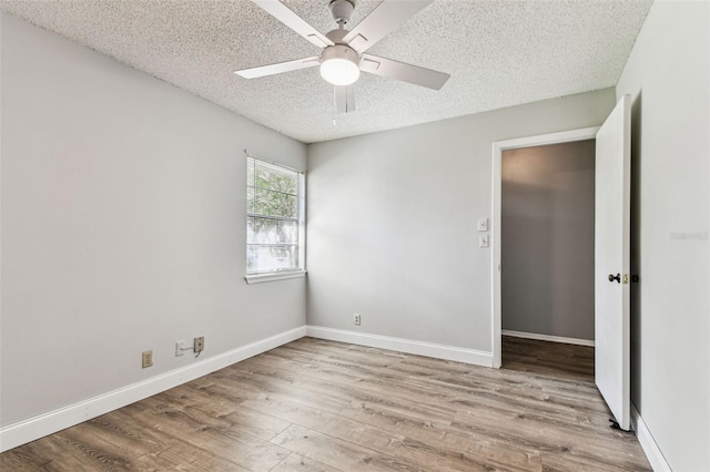 39650 US Highway 19 N Unit 143, Tarpon Springs, FL 34689 - empty room featuring a textured ceiling, ceiling fan, wood finished floors, and baseboards