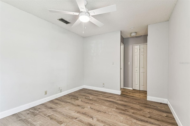 39650 US Highway 19 N Unit 143, Tarpon Springs, FL 34689 - unfurnished bedroom featuring wood finished floors, baseboards, a closet, a textured ceiling, and a ceiling fan
