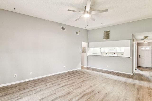 39650 US Highway 19 N Unit 143, Tarpon Springs, FL 34689 - unfurnished living room featuring a ceiling fan, light wood-style floors, a towering ceiling, baseboards, and a textured ceiling
