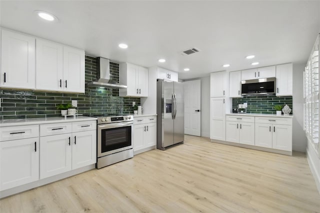 14170 Fennsbury Dr, Tampa, FL 33624 - kitchen featuring appliances with stainless steel finishes, wall chimney exhaust hood, decorative backsplash, light countertops, and white cabinets