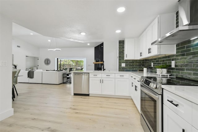 14170 Fennsbury Dr, Tampa, FL 33624 - kitchen with appliances with stainless steel finishes, wall chimney exhaust hood, open floor plan, white cabinetry, and a peninsula