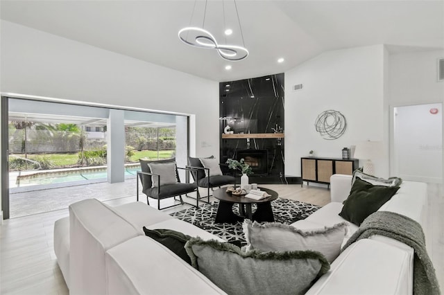 14170 Fennsbury Dr, Tampa, FL 33624 - living room featuring vaulted ceiling, wood finished floors, a chandelier, a fireplace, and recessed lighting