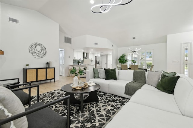 14170 Fennsbury Dr, Tampa, FL 33624 - living area featuring a chandelier, light wood-type flooring, and high vaulted ceiling