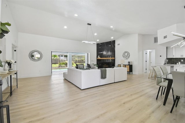 14170 Fennsbury Dr, Tampa, FL 33624 - living area with a fireplace, high vaulted ceiling, light wood-type flooring, recessed lighting, and baseboards