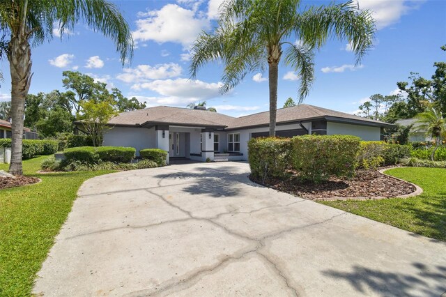 14170 Fennsbury Dr, Tampa, FL 33624 - ranch-style home featuring stucco siding, a front lawn, and concrete driveway