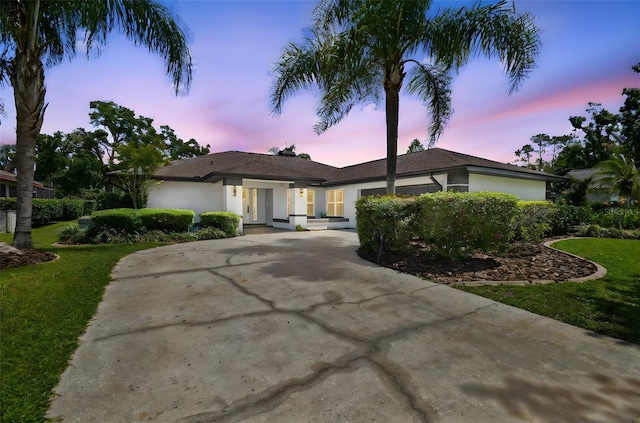 14170 Fennsbury Dr, Tampa, FL 33624 - ranch-style home with stucco siding, concrete driveway, and a front lawn