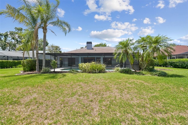 14170 Fennsbury Dr, Tampa, FL 33624 - back of house with a yard, glass enclosure, and a chimney