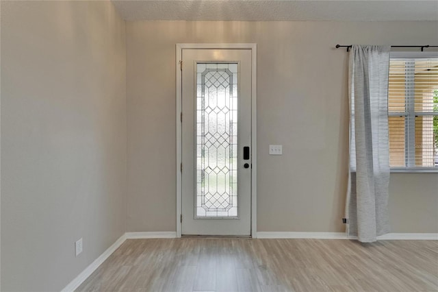 foyer entrance featuring light wood finished floors and baseboards